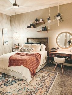 a bedroom with a bed, desk and mirror on the wall next to an area rug