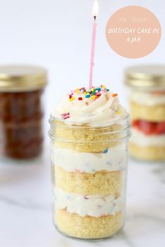 a birthday cake in a jar with a lit candle sticking out of it's top