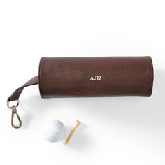 a golf ball, tee and leather case on a white background with an air logo