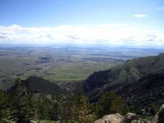 a view from the top of a mountain looking down on mountains and valleys in the distance