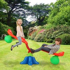 two children are playing in the park on colorful balls and sees - o - rings