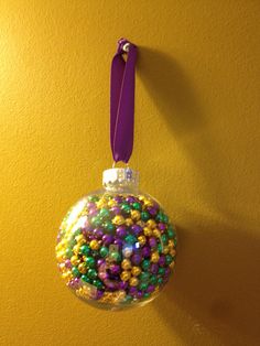 a glass ornament hanging on a wall with beads in the shape of a ball