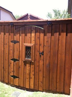 a wooden fence with a bird feeder on it's side and an open window