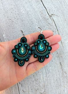 Black green soutache earrings will perfectly accentuate your look. They will complement your everyday outfits and evening gowns.  Ready to ship!      Soutache earrings are very light! And it is their great benefit! You will not feel them in your earlaps despite their big size!      The earrings are made in soutache technique using a soutache cord, glass and crystal beads. The fixture is rhodium-plated and will not cause allergy.      If you would like to have these earrings in a different color, send me a personal message and we will talk it through. A bracelet or a necklace can also be made to complement these earrings. Feel free to contact me and we will discuss your wishes and requests.      See the other jewelry from my store. https://www.etsy.com/shop/MagicalSoutache Thank you for you Black Cabochon Wedding Jewelry, Soutache Brooch, Polymer Clay Soutache, Motif Soutache, Textile Earrings, Soutache Necklace, Soutache Earrings, Green Jewelry, Jewelry Making Tutorials