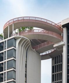 two tall buildings with a red and white walkway going up the side of one building