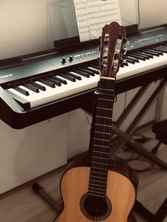 an acoustic guitar sitting in front of a keyboard