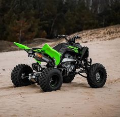 a green and black four wheeler on sand