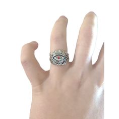 a person's hand wearing a ring with an evil eye on the middle finger