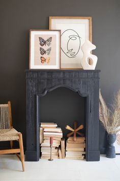 a black fireplace with books and pictures on it