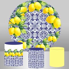 a blue and white plate with lemons on it, next to two yellow cups