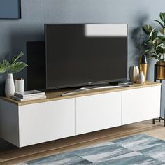 a flat screen tv sitting on top of a white entertainment center