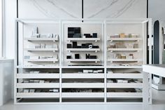 the shelves are filled with different types of cosmetics and beauty products in white, marble - like surfaces