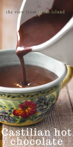 chocolate being poured into a bowl with the words castilian hot chocolate on it