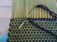 a close up of a piece of cloth with knitting needles