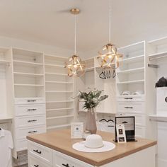 a kitchen with white cabinets and lights hanging from the ceiling