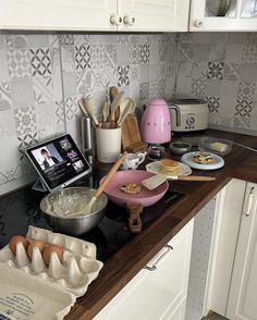 the kitchen counter is cluttered with cooking utensils