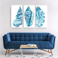 two blue seashells are hanging on the wall next to a couch and coffee table