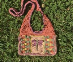 a crocheted purse laying on the grass