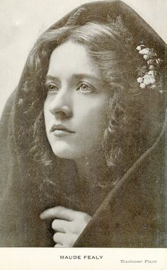 an old black and white photo of a woman wearing a veil with flowers in her hair