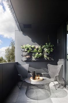 an image of a balcony with two chairs and a table on the ground, in front of