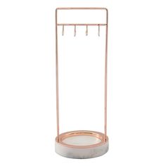 a white marble and copper metal stand with hooks