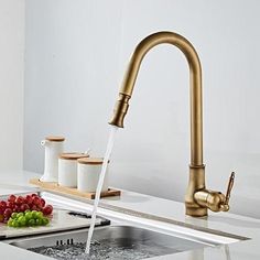 a faucet running water from a kitchen sink with fruit on the counter next to it