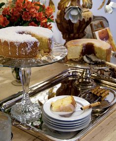 a cake sitting on top of a metal tray next to plates and bowls filled with food