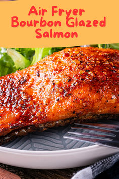 a piece of salmon on a plate with lettuce in the background and text overlay that reads air fryer bourbon glazed salmon