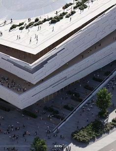 an aerial view of people walking around the outside of a large building with two levels