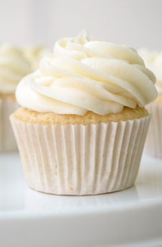 cupcakes with white frosting sitting on a plate