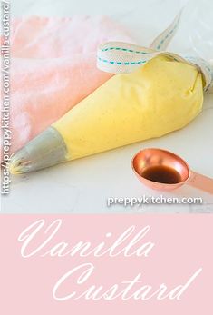 a pink and gold spoon sitting on top of a table next to an empty bag