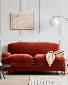 a living room with a red couch and white walls