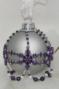 a silver ornament with purple beads on it