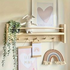 a wooden shelf with pictures hanging on it and a stuffed animal sitting on top of it