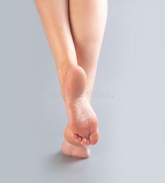 a woman's bare feet and toes on a gray background