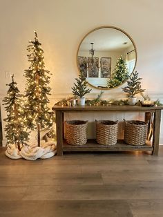 christmas trees and baskets are on the floor in front of a table with a mirror