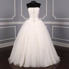 a white wedding dress on display in a room