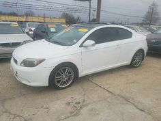 a white car parked in a lot next to other cars