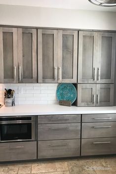 an empty kitchen with stainless steel cabinets and white counter tops, including a dishwasher