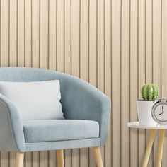 a blue chair next to a white table with a clock on it