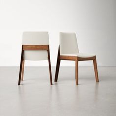 two white chairs sitting next to each other