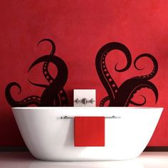 an octopus wall decal in a bathroom with red walls and white bathtub next to the sink