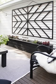 a black and white bench sitting on top of a wooden deck next to a building