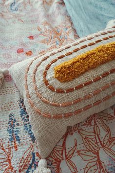 a close up of a decorative pillow on a bed