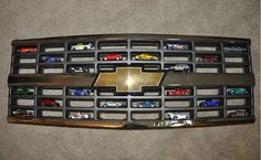 the front grille of a car with many toy cars on it's grills