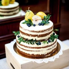 wedding cake decorated with fruit and greenery