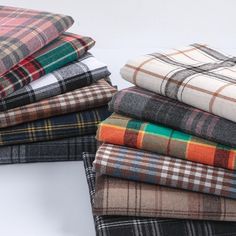 a pile of plaid fabric sitting on top of a white table next to each other