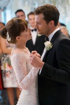 a bride and groom dance together in front of an audience