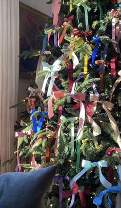 a decorated christmas tree with ribbons on it