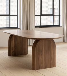 an image of a wooden table in the middle of a room with windows and curtains